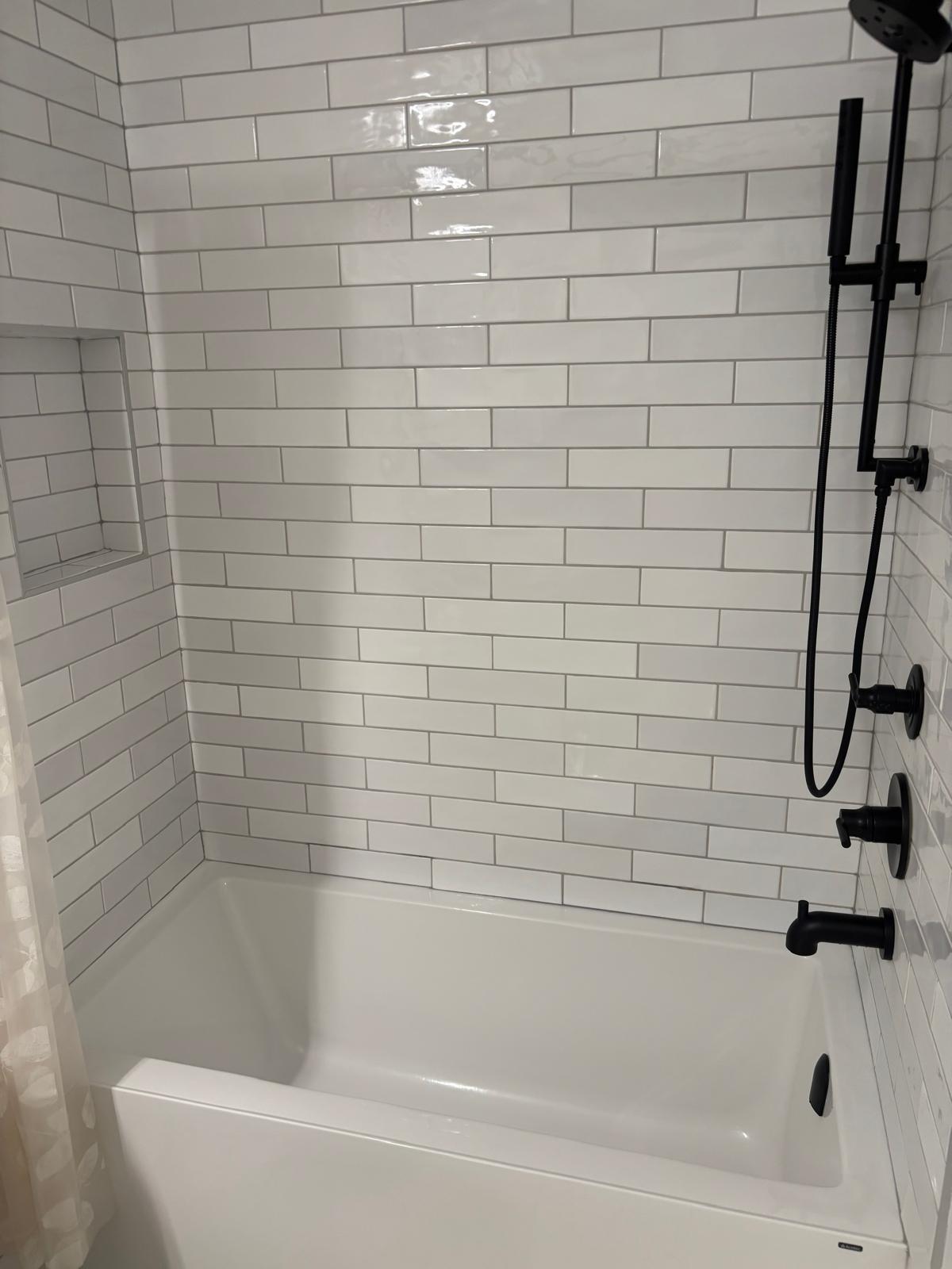 Tiled bathtub and shower with black fixtures