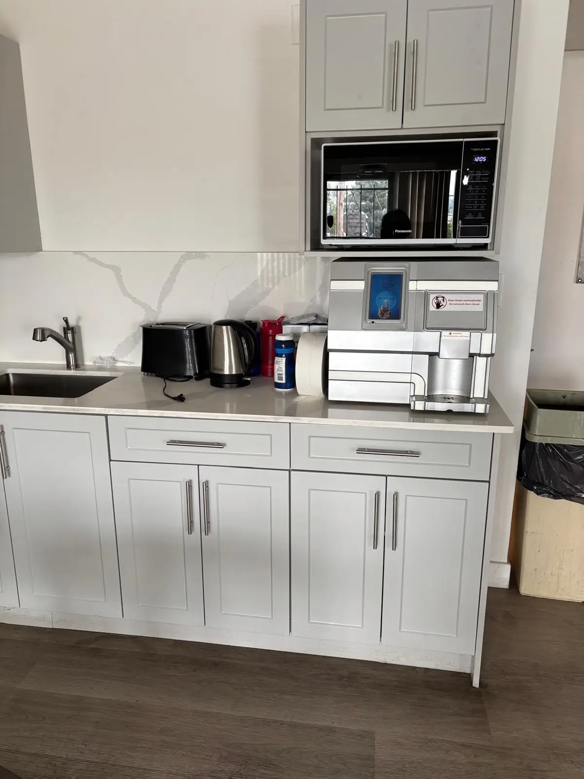 Office kitchenette with white cabinets